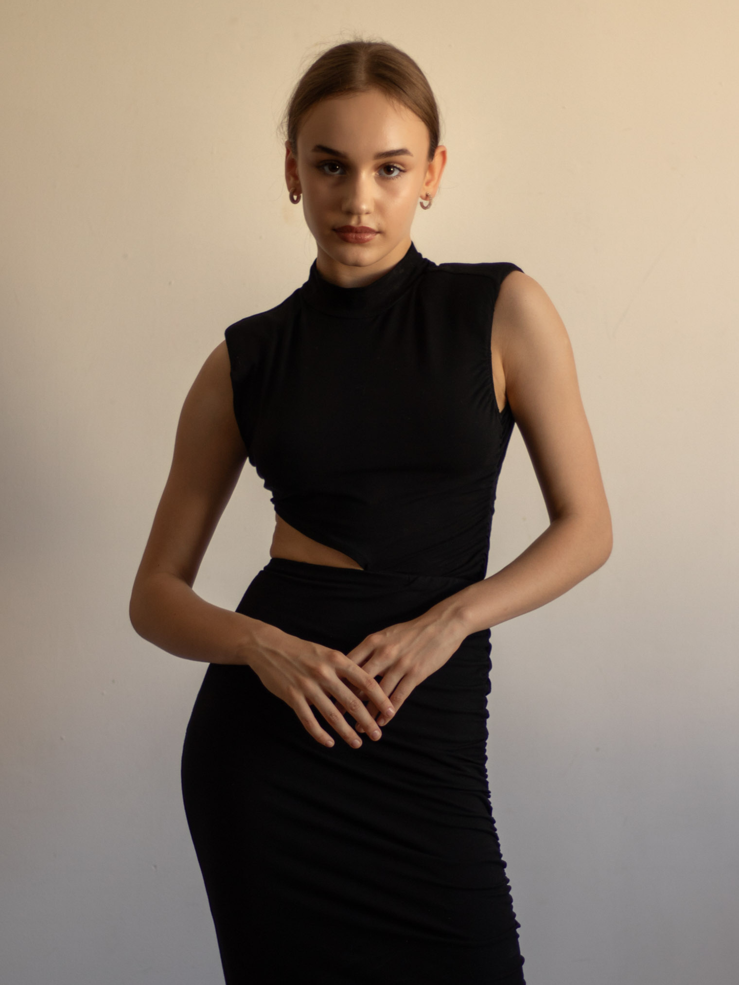 Asymetryczne wycięcie zaczynające się pod biustem po lewej stronie odsłania fragment brzucha, dodając pikanterii. Czarna dzianina jest gładka i matowa, co nadaje sukience nowoczesnego minimalizmu. To ujęcie pozwala skupić się na starannym wykończeniu – brak widocznych szwów na krawędziach wycięcia i dekoltu świadczy o jakości wykonania. Sukienka Uranus w tym detalu pokazuje, że czasem mniej znaczy więcej, a pojedyncze cięcie potrafi uczynić kreację niezapomnianą.